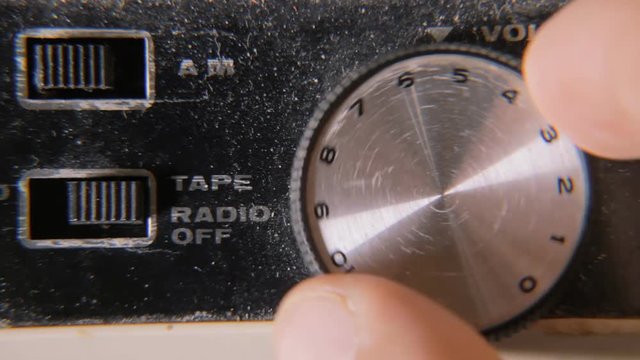 Shifting the dialer volume from ten to zero on a damaged old retro vintage cassette tape player.
