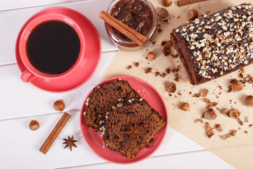 Dark cake with chocolate, cocoa and plum jam, cup of coffee, concept of delicious dessert