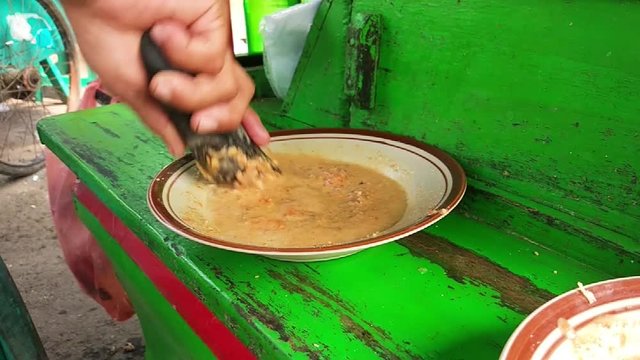 Grinding peanut sauce for Indonesian traditional food, Ketoprak, manually called ulekan in slow motion