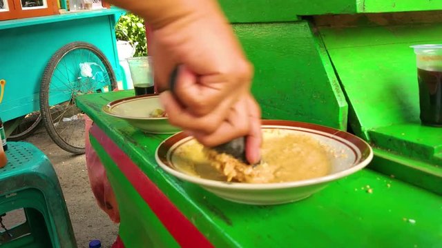 Grinding peanut sauce for Indonesian traditional food, Ketoprak, manually called ulekan