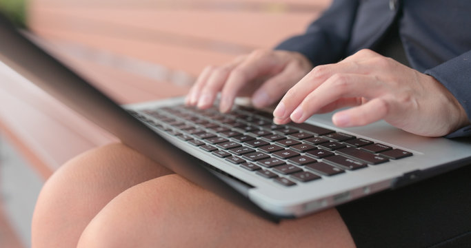 Businesswoman use of laptop computer and sitting on bench