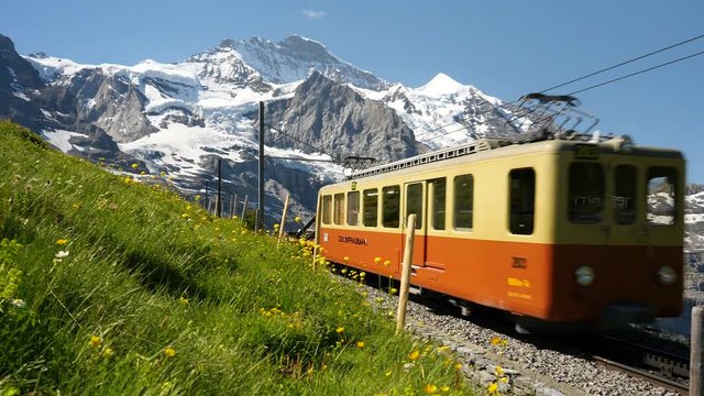 Jib shot of a maintenance train travelling uphill toward the Jungfrau Mountain range from Kleine Scheidegg