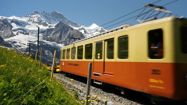 Jib shot of a maintenance train travelling downhill from the Jungfrau Mountain range toward Kleine Scheidegg