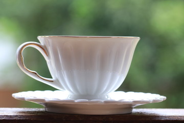 Close up black coffee in white ceramic cup on green background
