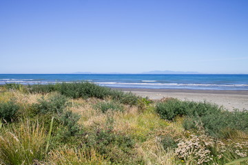Fototapeta na wymiar Landscape view from Paraparaumu Beach in Kapiti, Wellington, looking out across the Tasman Sea to the South Island of New Zealand.