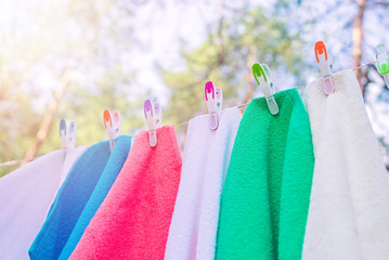 Colorful laundry is dried with plastic colorful clothespins on a rope, outside