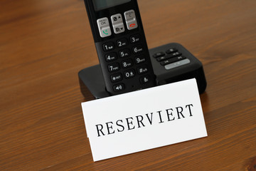 Telefon mit Schild Reservierung