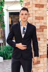 Young stylish handsome man posing in modern city park