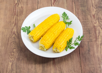 Boiled ears of sweet corn on a white dish