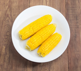 Boiled sweet corn on white dish on the rustic table