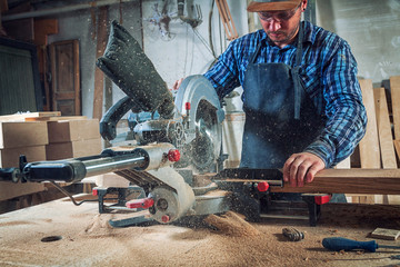 Carpenter work with circular saw for cutting boards, the man sawed bars, construction and home...