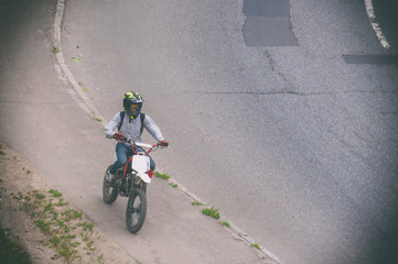 Obraz premium A young guy is riding a motorcycle on the sidewalk