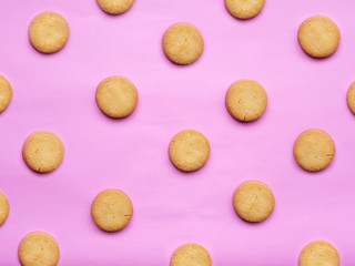 round Danish butter cookie isolated on pink background. cookies pattern for background. creative pastels and pastel minimalism concept.