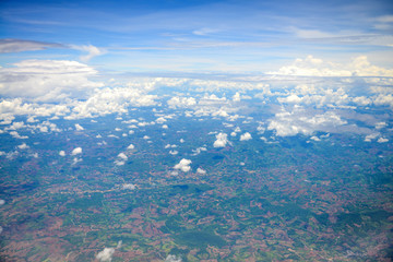Fototapeta premium Beautiful view of blue sky above the white clouds and land background from airplane window
