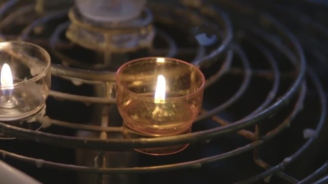 Handheld close up shot of candles in old french church