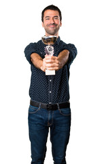 Happy Brunette man holding a trophy on isolated white background