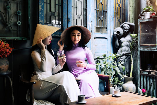 Vietnam woman wearing Ao Dai culture traditional drinking coffee at Ho Chi Minh in Vietnam,vintage style,travel and relaxing concept.