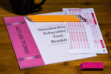A Standardized Test Booklet and Scannable Scantron Answer Sheet with 5 sharpened #2 pencils with an eraser.