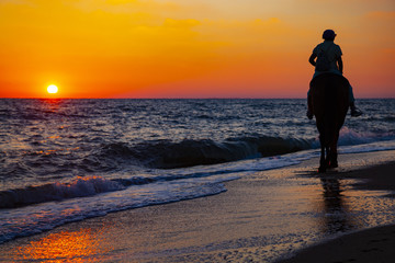 Woman riding a horse on the beach