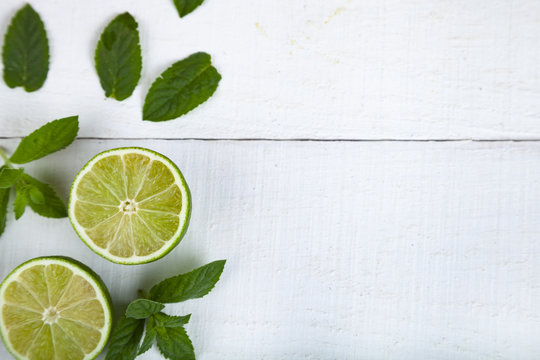 Lime and mint on a wooden table.