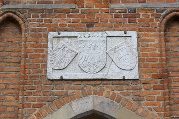 15th century Mariacka Gate by the river Motlawa, arm on the facade, Long Bridge, Gdansk, Poland