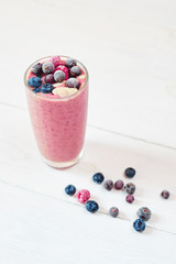 Glass of pink fruit smoothies milkshake or cocktail on white background, breakfast vegan and raw food, with a place for your text
