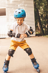 Fototapeta premium Outdoor portrait of boy with roller skates riding in the park