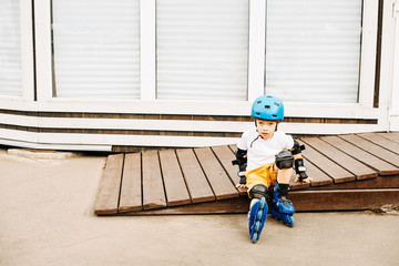 Boy sitting roller skates at outdoor park