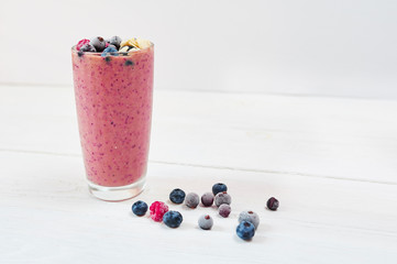 Glass of pink fruit smoothies milkshake or smoothie or cocktail on a white wooden background. Healthy juicy vitamin drink diet or vegan food concept
