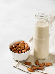 Bottle with almonds milk and some almonds