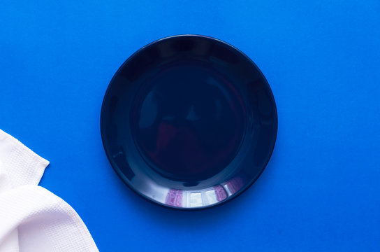 Empty Plate And White Dish Cloth On The Blue Kitchen Table.