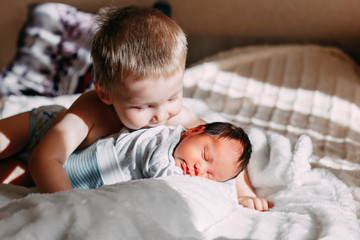 elder brother kissing newborn baby sister