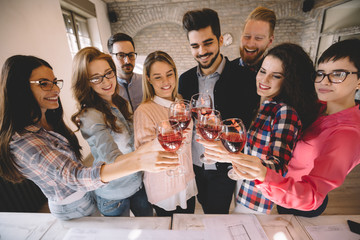 Group of successful architects celebrating in office