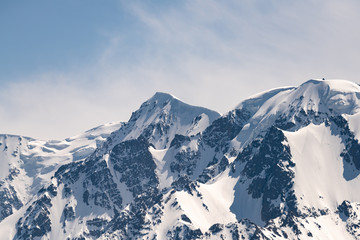 Fototapeta na wymiar Mountain peaks covered with white shiny snow.