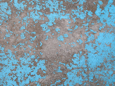 Old peeling blue paint on the concrete wall. Grunge stucco background