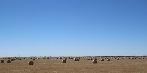 Wide agricultural used land with hay bales under blue skies in South Australia