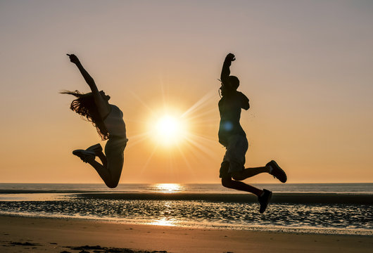 jeune couple sautant sur la plage