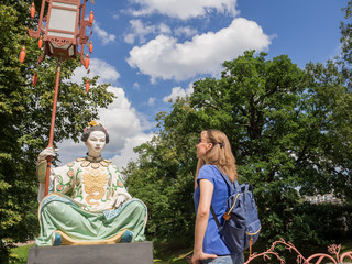The tourist looks at the ancient Chinese statues on the Big Chinese Bridge in Tsarskoye Selo. Russia