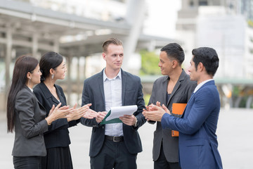 Obraz premium Confident and Active Businesspersons Creative Business Meeting Outdoor.Boss Business Woman pointing Forefinger Up.Startup Running The New Project Plan.Dealing, Merger and Acquisition Concepts.