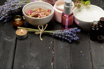 Obraz na płótnie Canvas Aromatic composition of lavender, herbs, cosmetics and salt on a dark table top