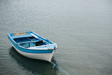 A small lonely fishing boat on calm water