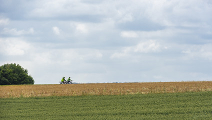 Fototapeta na wymiar Agricultural fields and two bicyclists