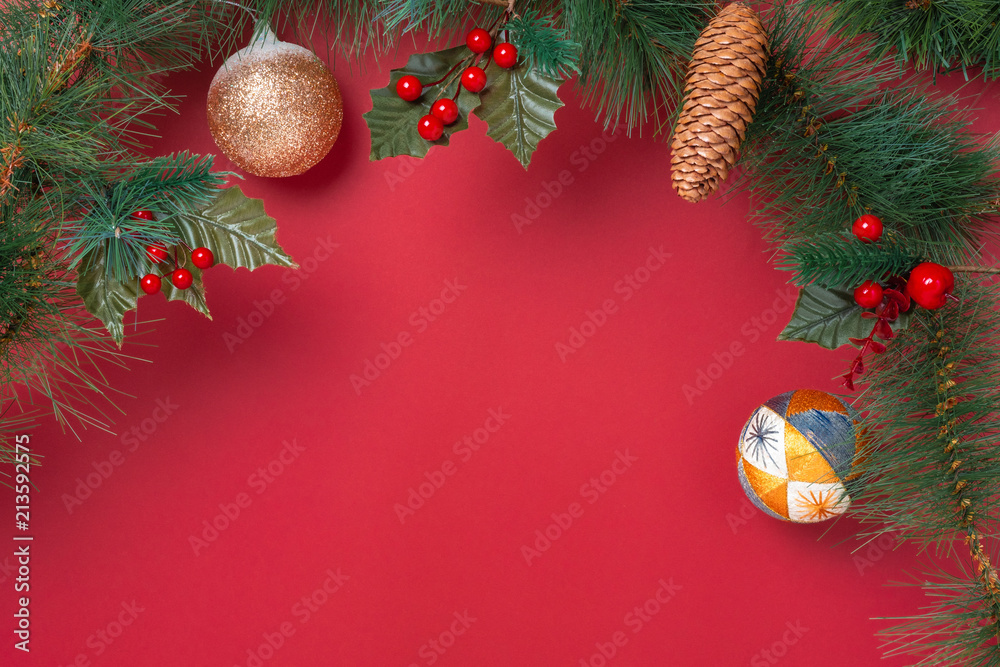 Poster christmas decoration and fir branches wreath with cherry and pine cone on red table background. wint