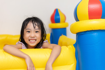 Fototapeta na wymiar Asian Little Chinese Girl playing at inflatable castle