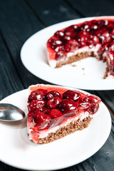 cake with cherry on dark wooden board