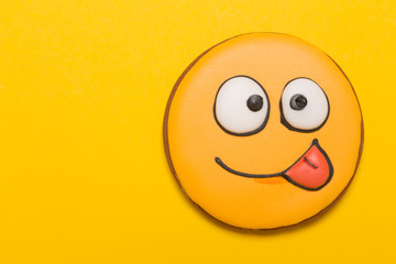 cookie smile and emotions, stick out tongue on one side, baby gingerbread, on yellow background, concept