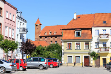 Gniew in polish Pomerania -Tenements at  old town market. In  background a fragment of a medieval Teutonic castle from red brick