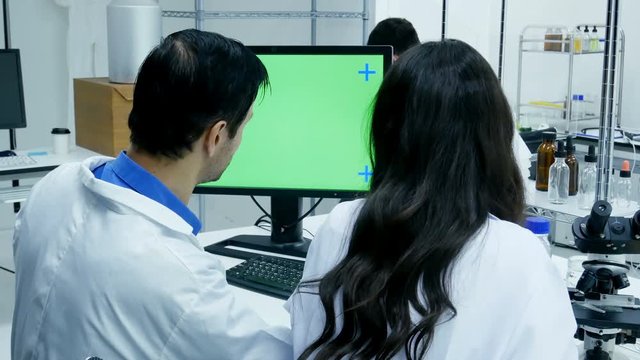 Scientist looking to green screen together. Scientist working together at lab. People with science concept. 4K Resolution.