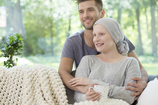 Smiling couple at home. Husband supporting sick wife after chemotherapy