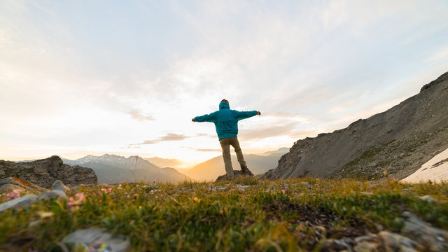 Man Standing On Mountain Top Outstretching Arms, Sunrise Light Colorful Sky Scenis Landscape, Conquering Success Leader Concept.